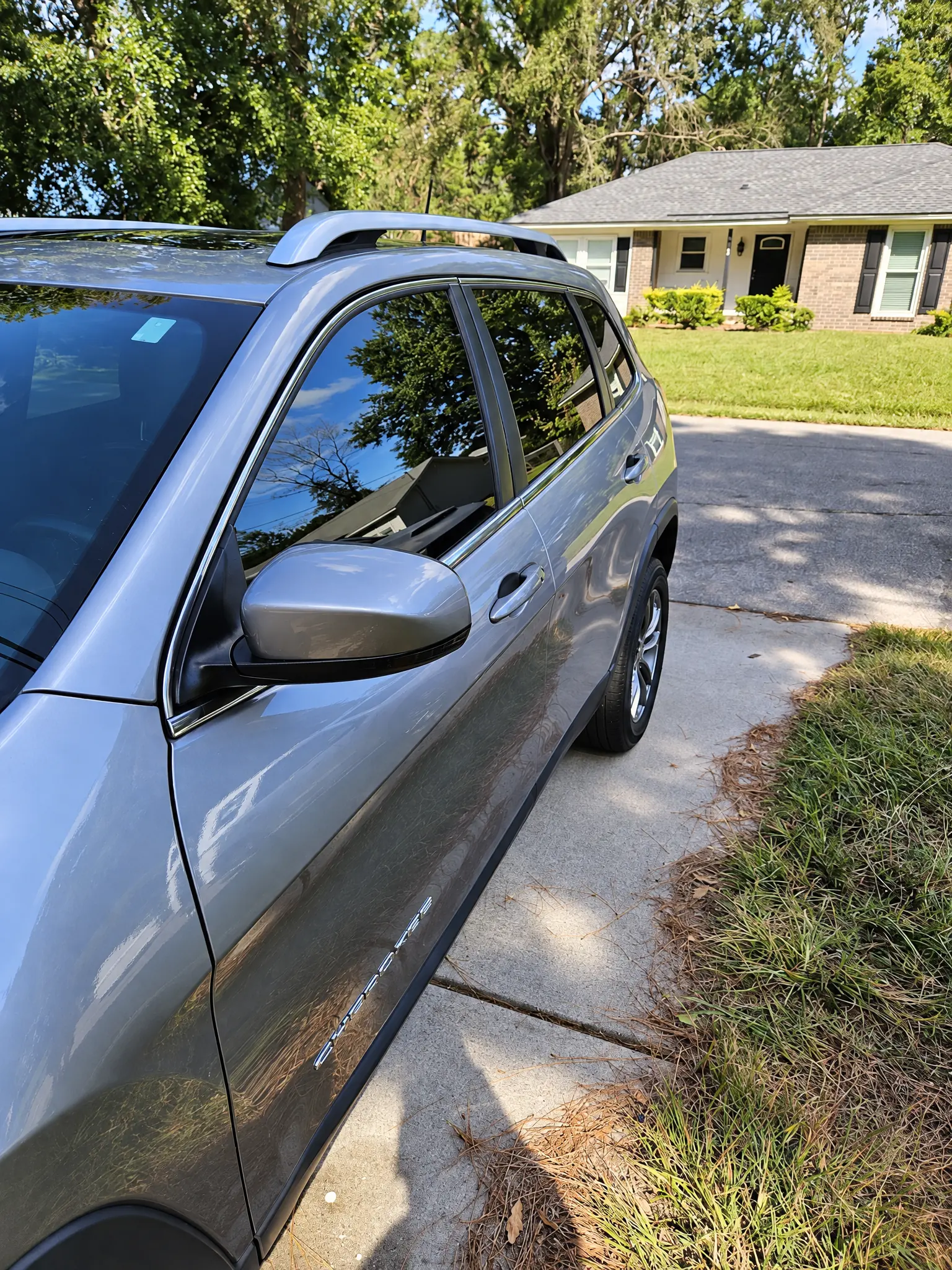 A silver SUV with tinted side windows on a driveway