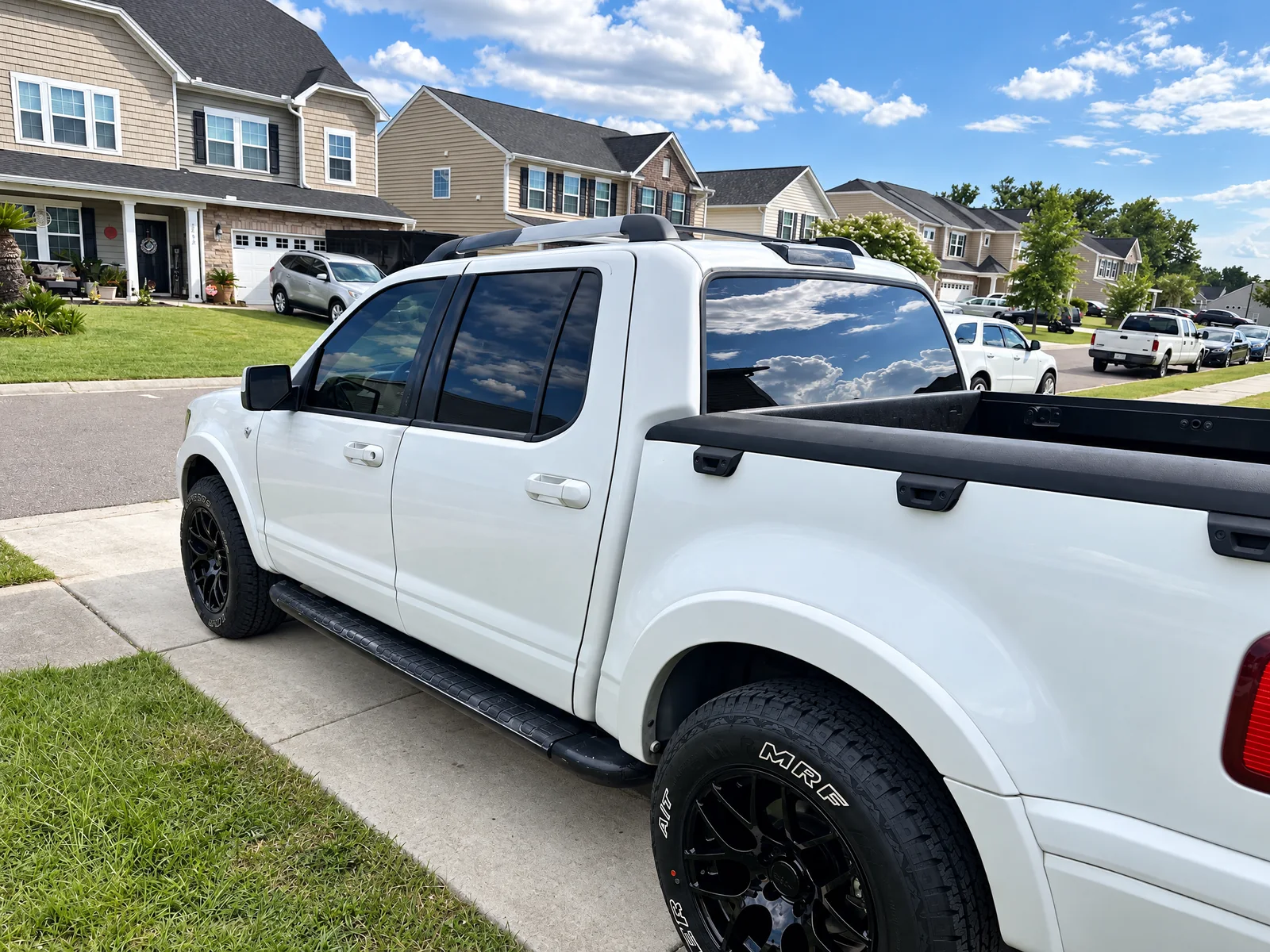 A white Ford Explorer Sport Trac with tinted rear windows on a driveway
