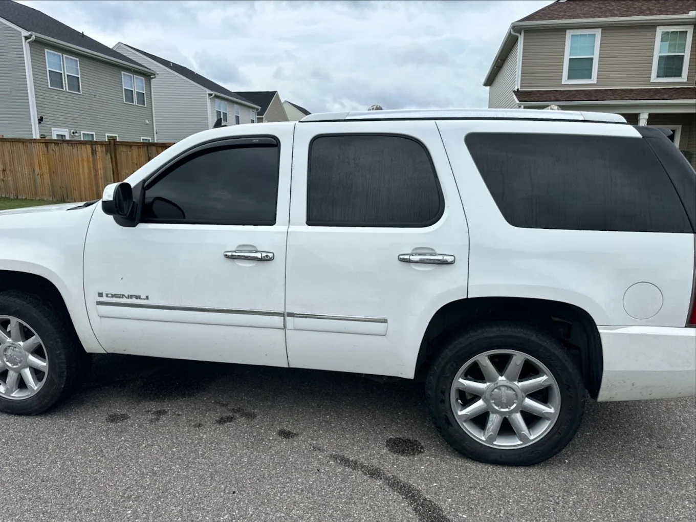 A white GMC Yukon Denali with tinted windows